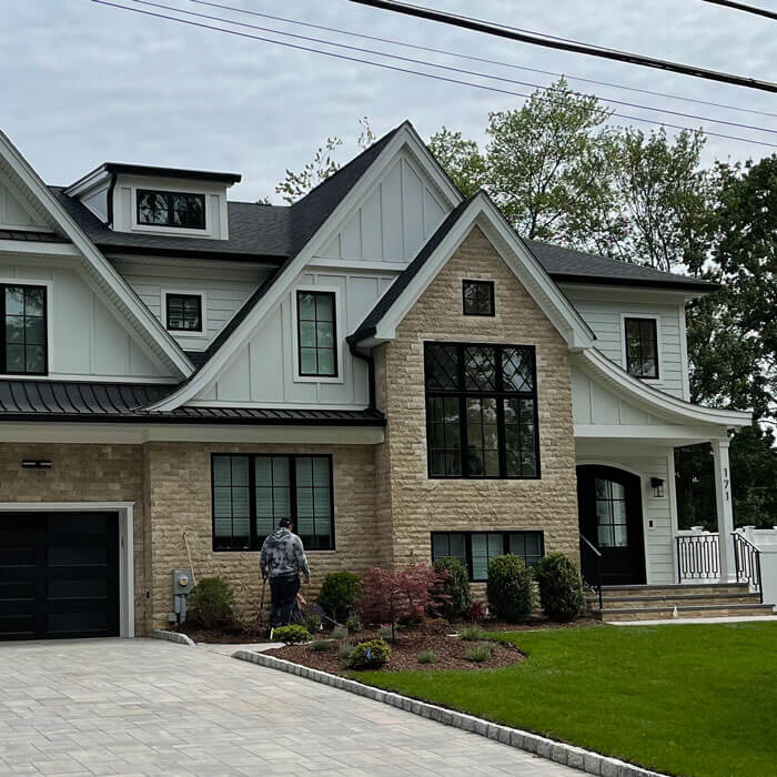 gray stone driveway and tan stone siding on custom house